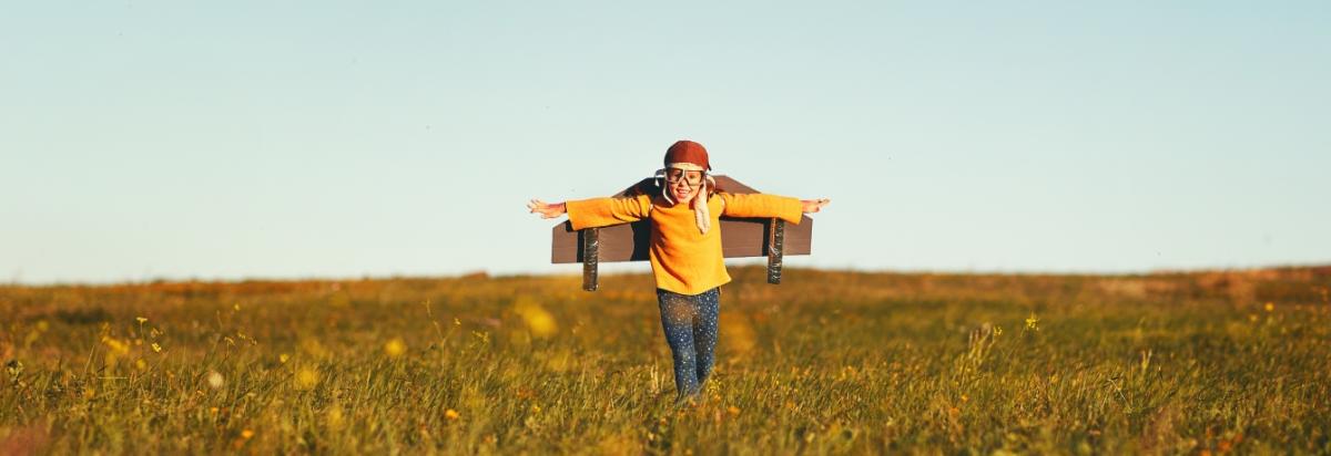 Kind auf Feld spielt Flugzeug