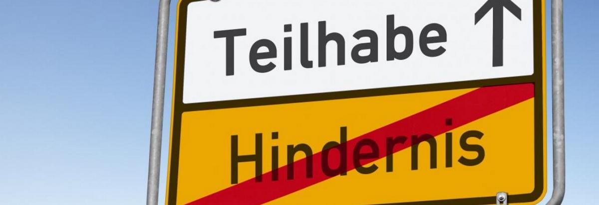 Verkehrsschild mit den Worten Teilhabe / Hinderniss