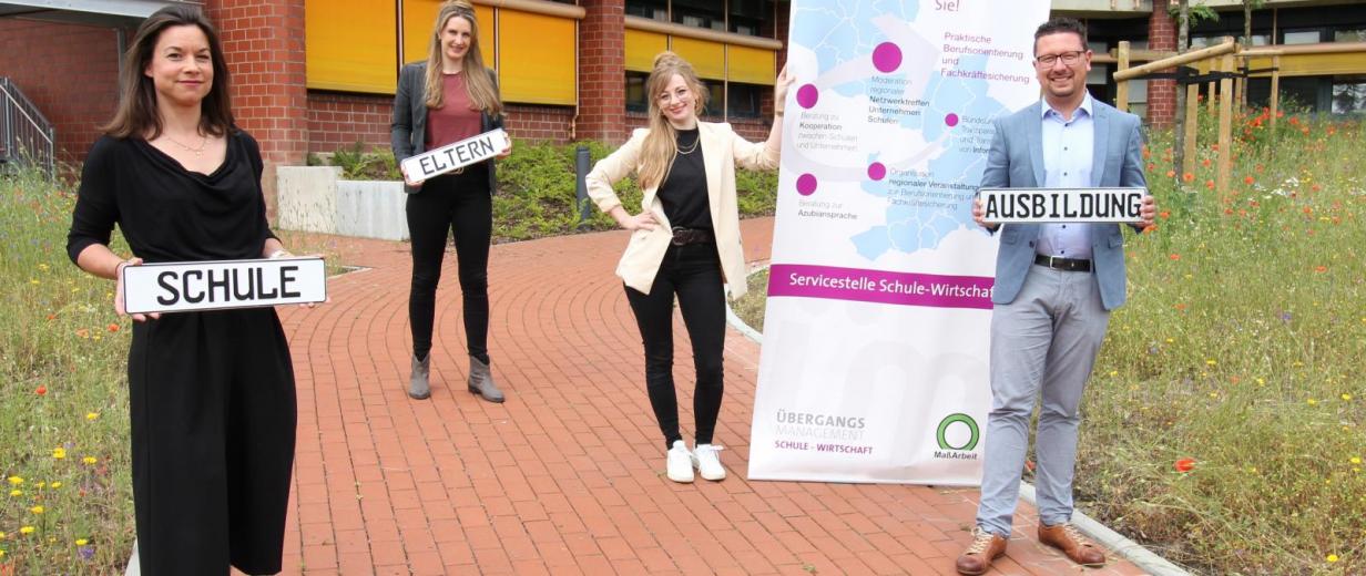 4 Personen vor Kreishaus mit Plakat