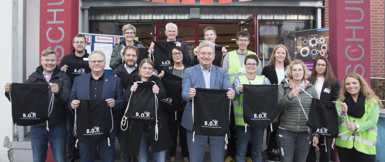 BOP Bramsche Eine Personengruppe hält Stoffbeutel in die Kamera.
