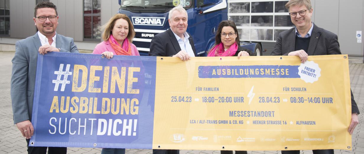 5 Personen in Reihe vor Plakat