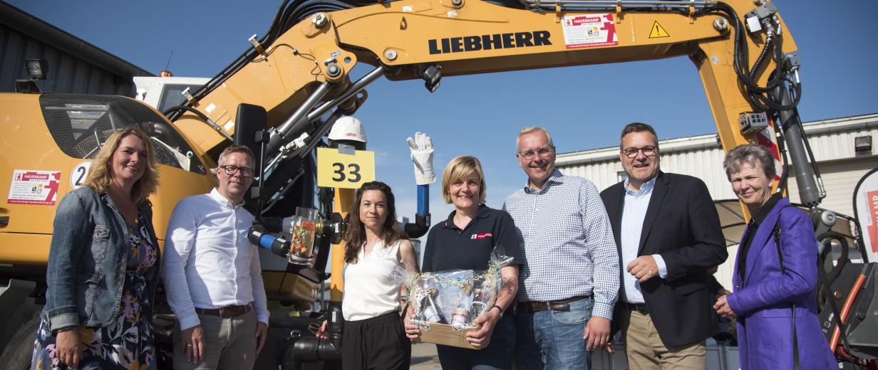 Gruppe von Personen vor Bagger