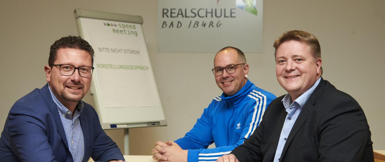 46 Unternehmen stellten sich in der Realschule Bad Iburg Jugendlichen vor 3 Personen an einem Tisch