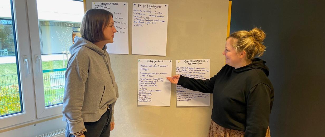 2 Personen vor Plakatwand