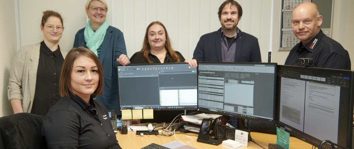 Gruppe von Personen im Büro vor PCs