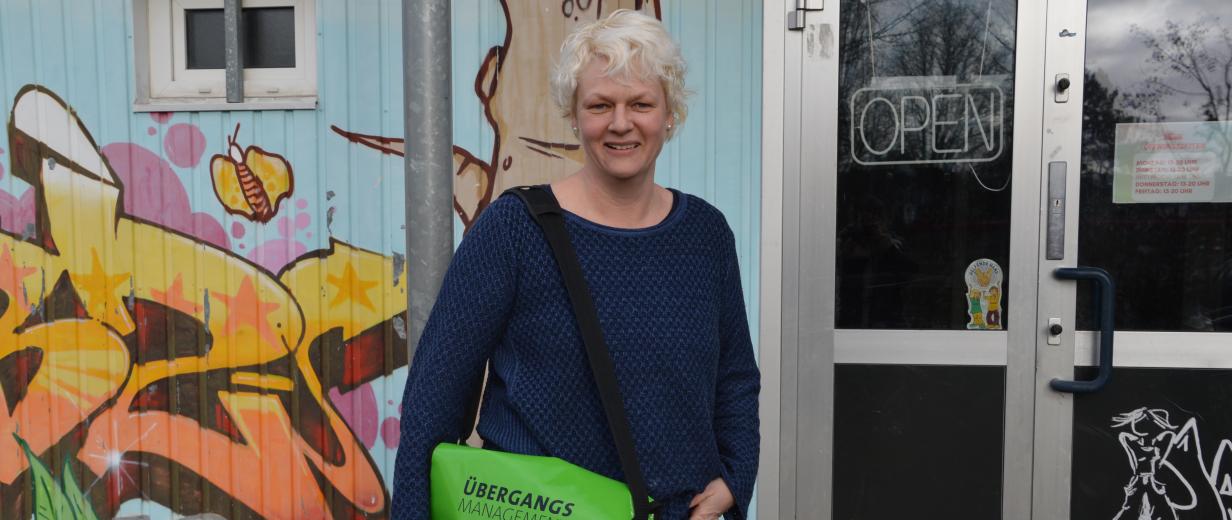 Ausbildungslotsen Kristina Flaßpöhler MaßArbeit Eine Person steht vor einem Gebäude mit Glastür.