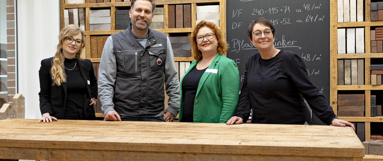 4 Personen vor einem Tisch stehend