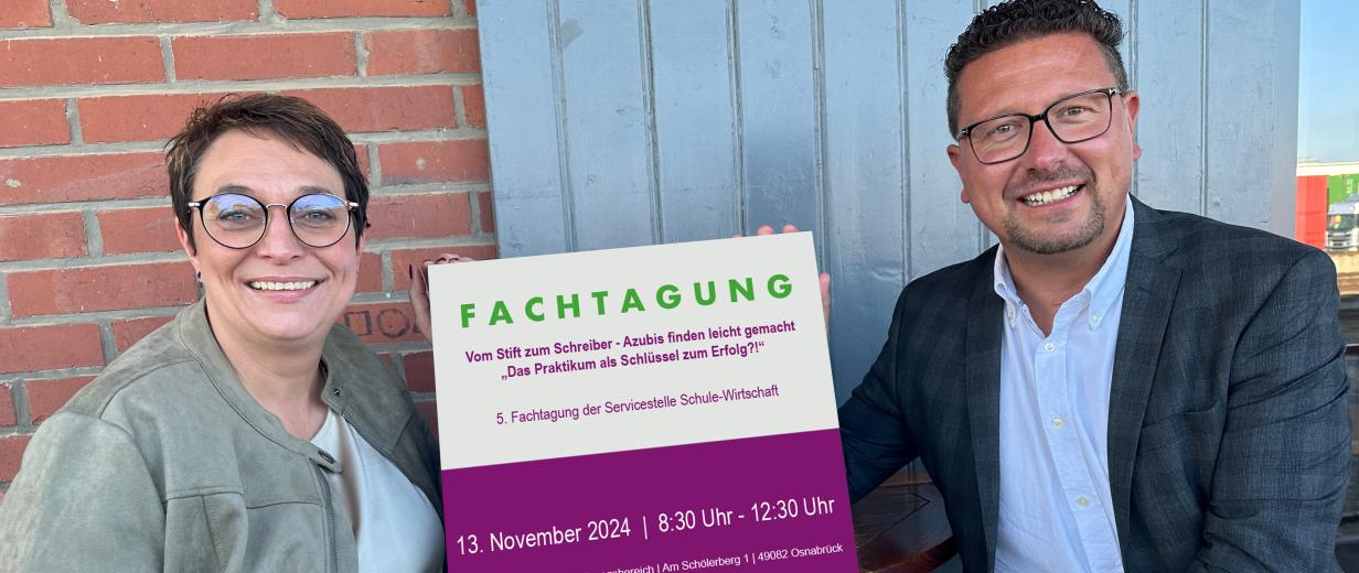 Fachtagung, MaßArbeit Zwei Personen halten ein Schild in die Kamera.