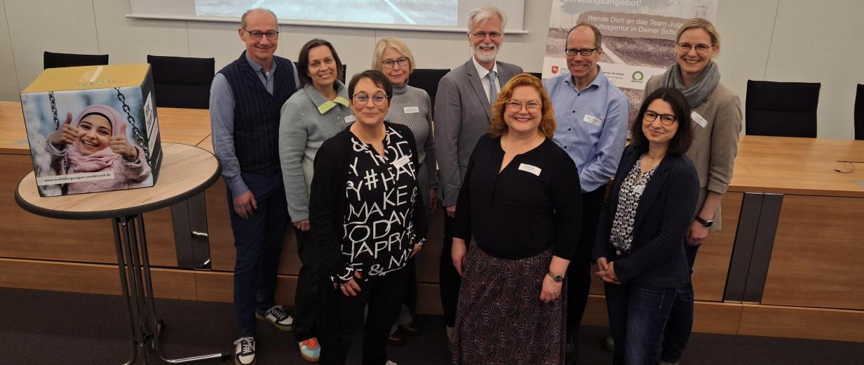 JBA Treffen, MaßArbeit Eine Personengruppe steht in einem Versammlungssaal.