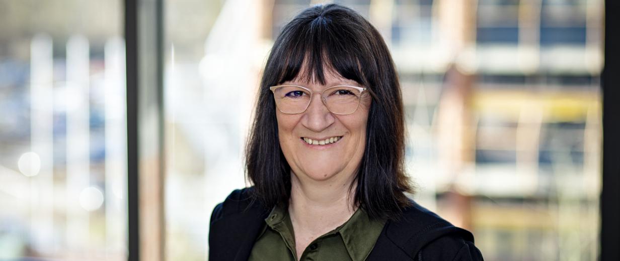 Melanie Flint ArbeitgeberService MaßArbeit Eine Person steht vor einem Fenster.