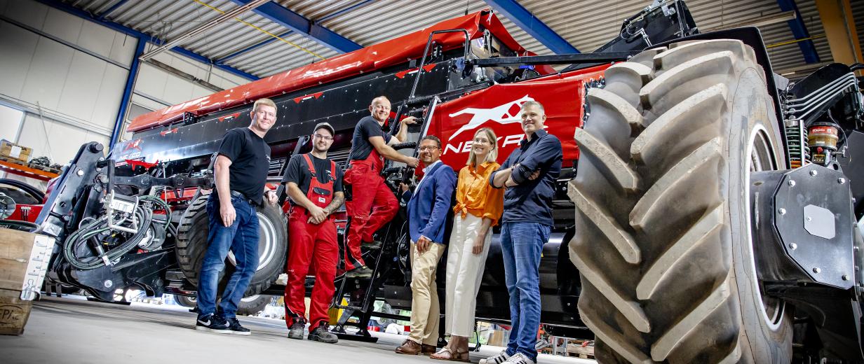 Gruppe von Personen in Halle vor Landmaschinen