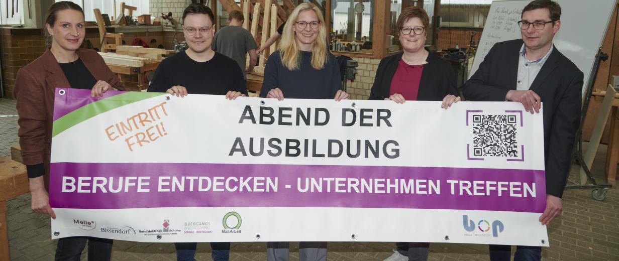 Fünf Personen stehen in einer Werkhalle