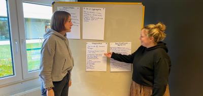 2 Personen vor Plakatwand