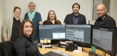 Gruppe von Personen im Büro vor PCs