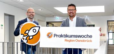 Zwei Personen stehen im Treppenhaus eines Bürogebäudes.