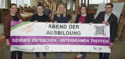 Fünf Personen stehen in einer Werkhalle