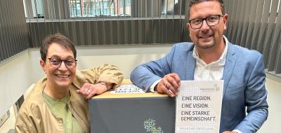 2 Personen vor Plakat
