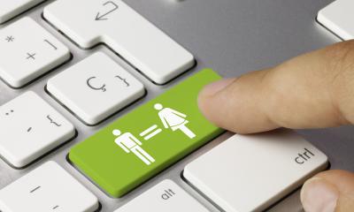 Computertastatur mit einer grünen Taste, auf der Piktogramme für Mann und Frau mit einem Gleichheitszeichen verbunden sind.