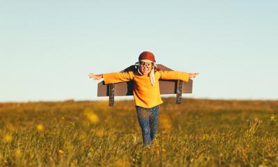 Kind auf Feld spielt Flugzeug