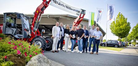 Gruppe von Personen vor Bagger