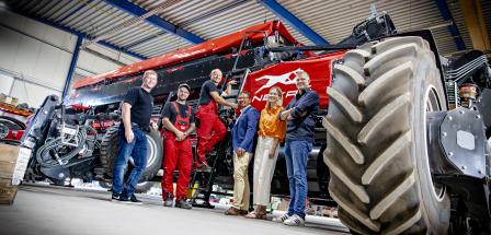 Gruppe von Personen in Halle vor Landmaschinen