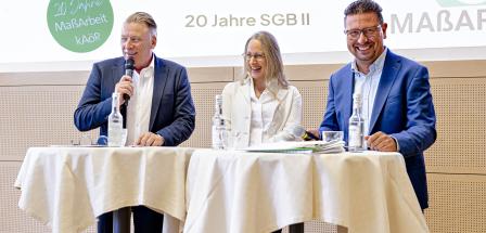 3 Personen vor Desk