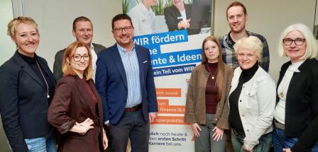 Gruppe von Personen vor Plakat