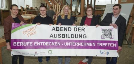 Fünf Personen stehen in einer Werkhalle