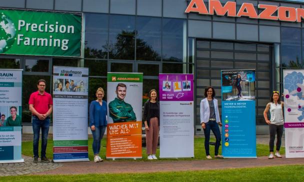 7 Personen mit Werbeplakaten vor dem Unternehmen Amazone