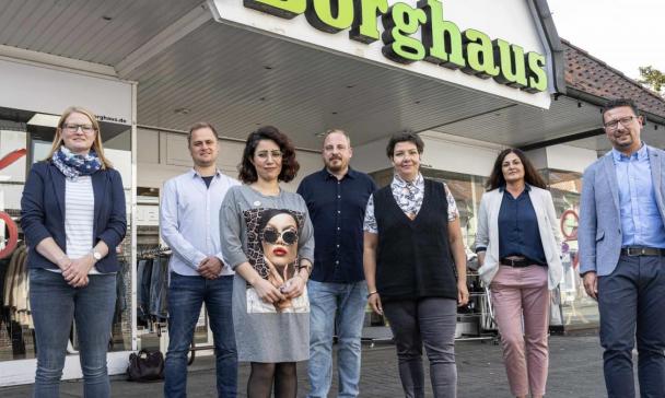 8 Personen vor Firmengebäude