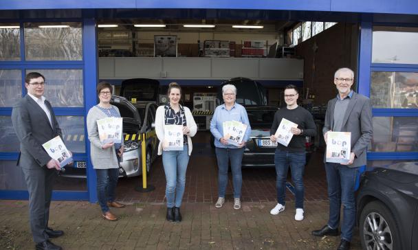 6 Personen vor Eingangstor Halle