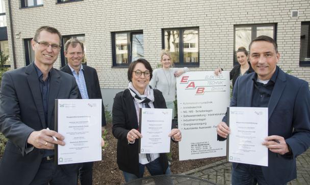 6 Erwachsene präsentieren eine Auszeichnung