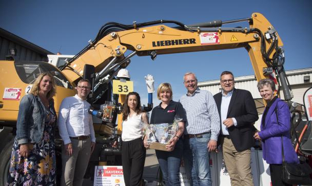 Gruppe von Personen vor Bagger
