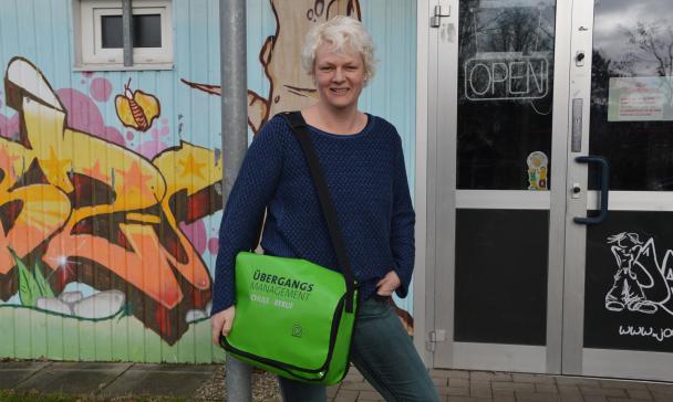 Eine Person steht vor einem Gebäude mit Glastür.