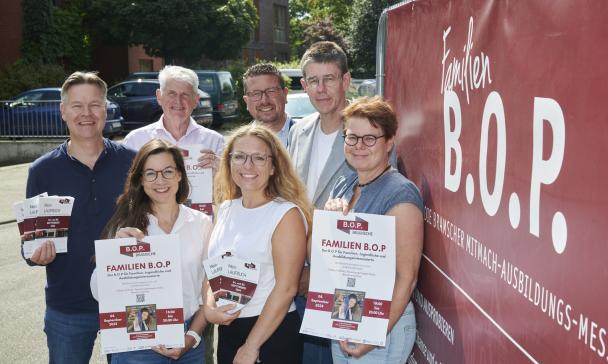 Gruppe von Personen vor Plakat