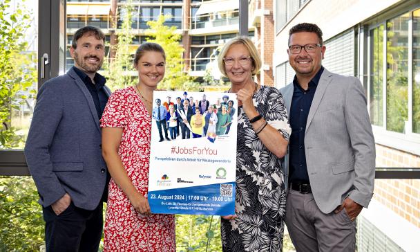 4 Personen mit Plakat im Freien