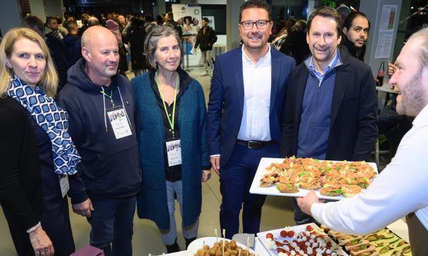 Fünf Personen stehen an einem Buffet.