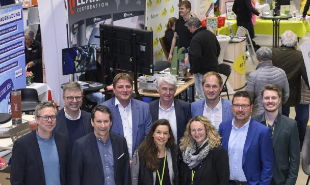 Eine Personengruppe steht in einer Werkhalle.