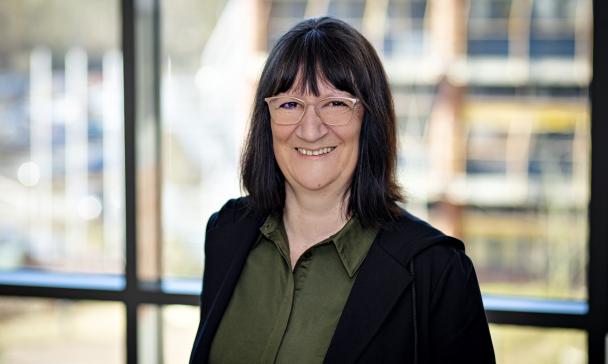 Eine Person steht vor einem Fenster. 