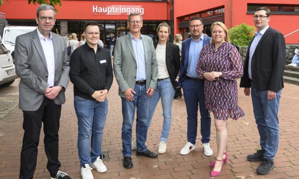 Gruppe von Personen vor Schule