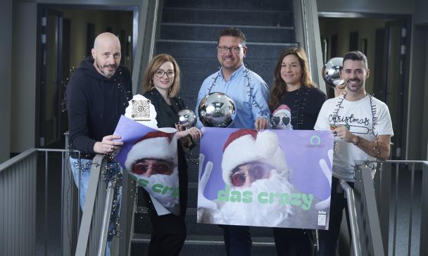 Fünf Personen mit Weihnachtsschmuck stehen in einem Treppenhaus.