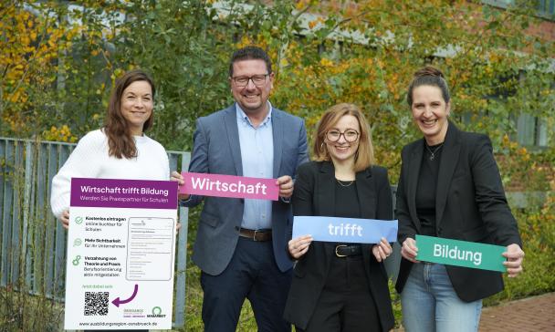 4 Personen mit Plakat im Freien