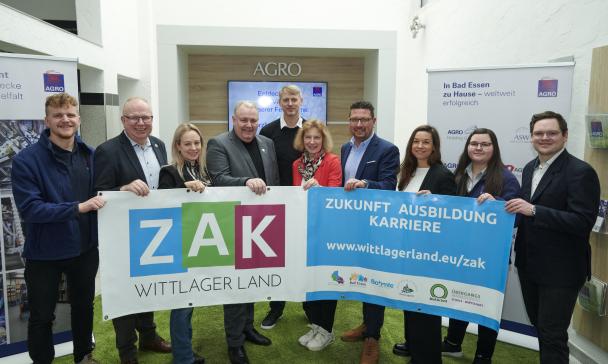 Gruppe von Personen vor Werbebanner