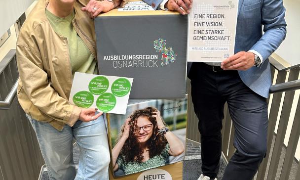 2 Personen vor Plakat